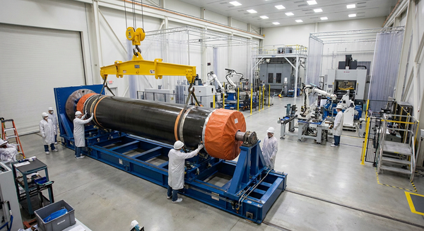 Solid rocket motor casing assembled on a precision fixture inside an aerospace manufacturing facility